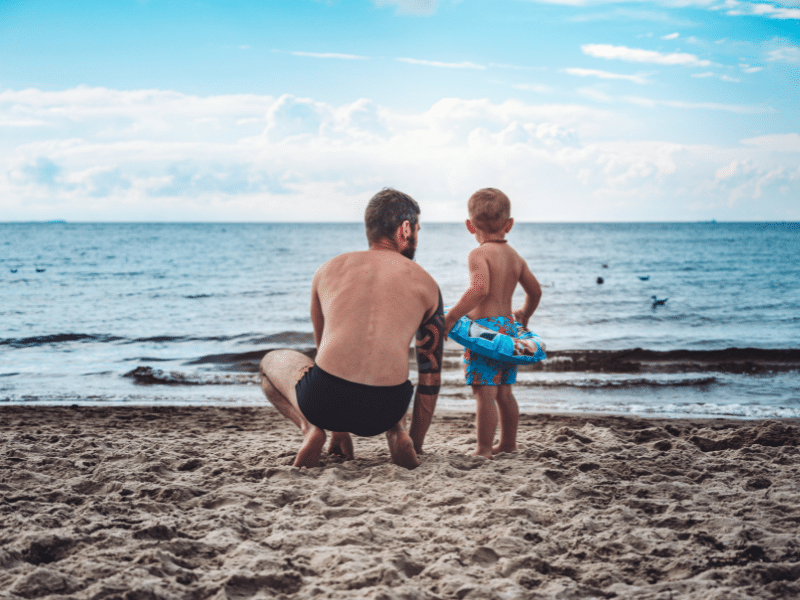 Father talking to his young son about beach safety