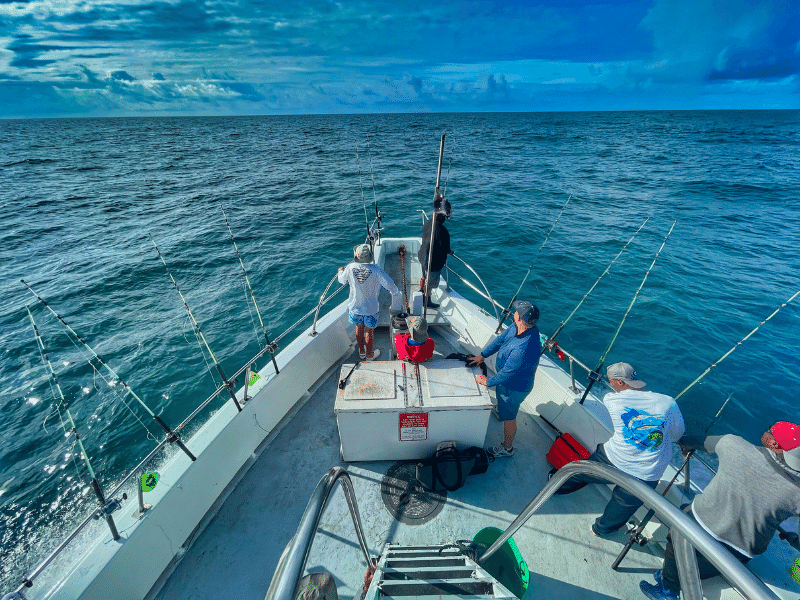 men on a crystal coast fishing charter boat with fishing poles cast into the water