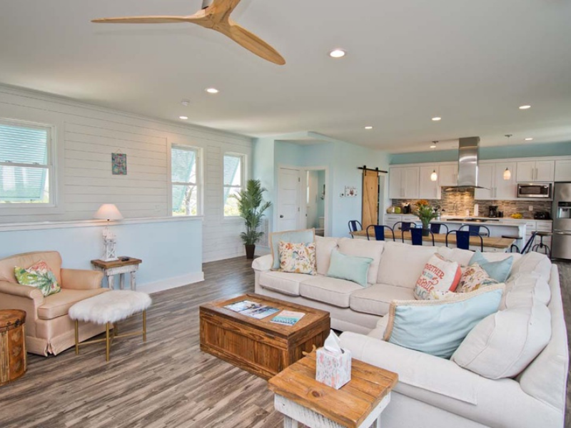 the interior of a beautiful bluewater vacation rental home with a relaxing color scheme and wood floors and stainless steel appliances in the kitchen