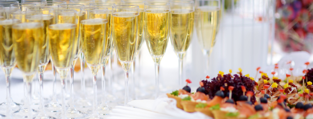 champagne flutes on a table with appetizers