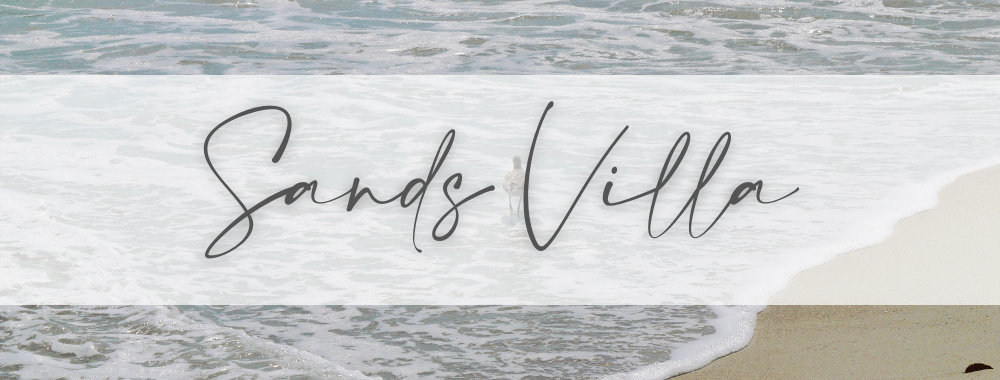 banner image of the beach shore with waves and the words Sands Villa overlaid