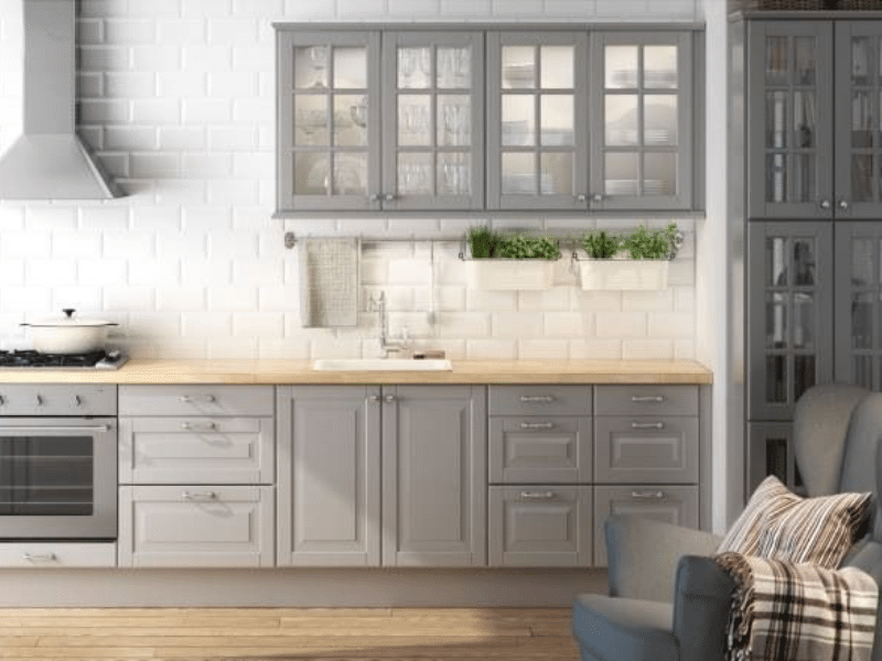 gray kitchen cabinets with subway tile backsplash and a gray appliances