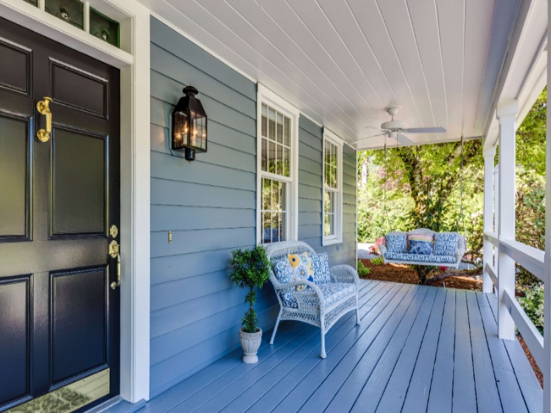 An inviting front porch with blue decking and white rails.