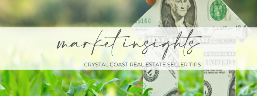 "Market Insights Crystal Coast Real Estate Seller Tips"A hand holds a paper house constructed from American dollar bills.